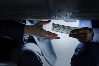 hands-passing-money-under-table-260nw-717005518.jpg
